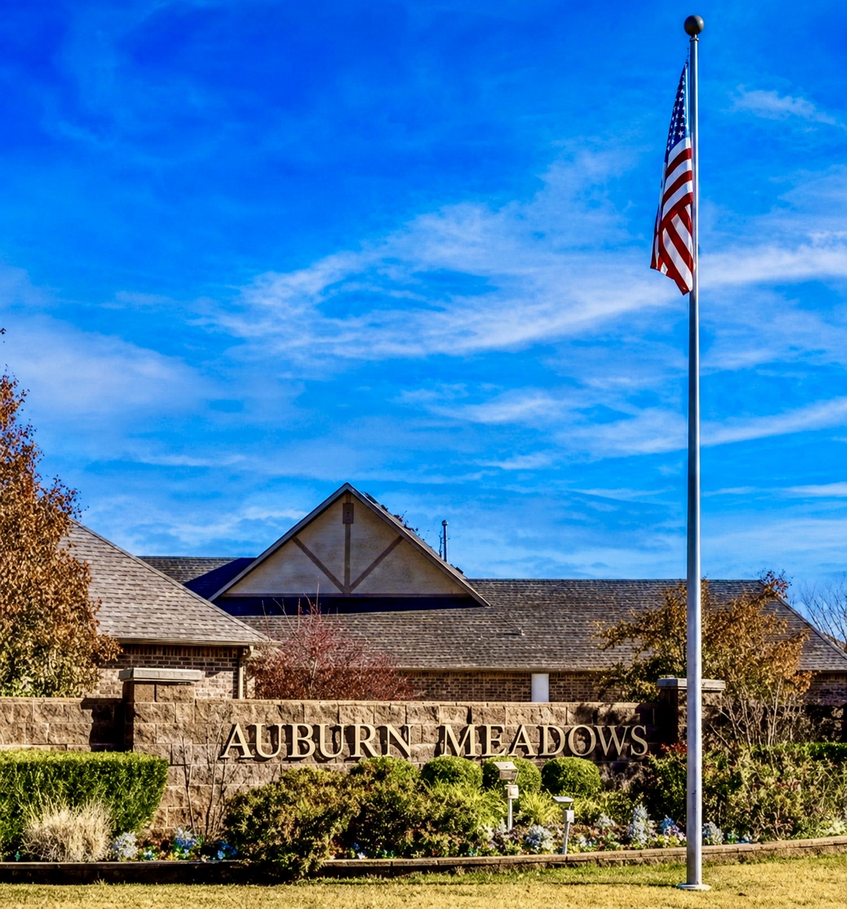 Auburn Meadows entrance sign and American flag